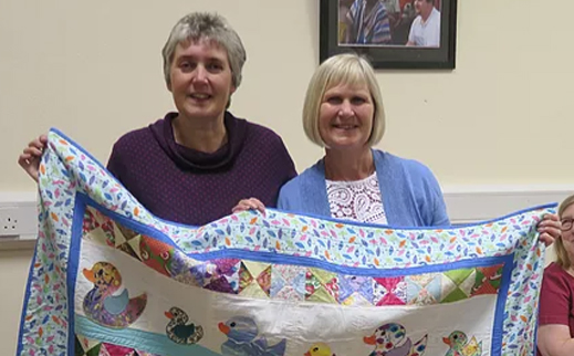 WI Patchwork group with quilt