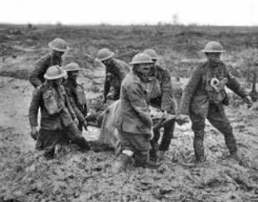 soldiers in the mud carrying someone on a stretcher